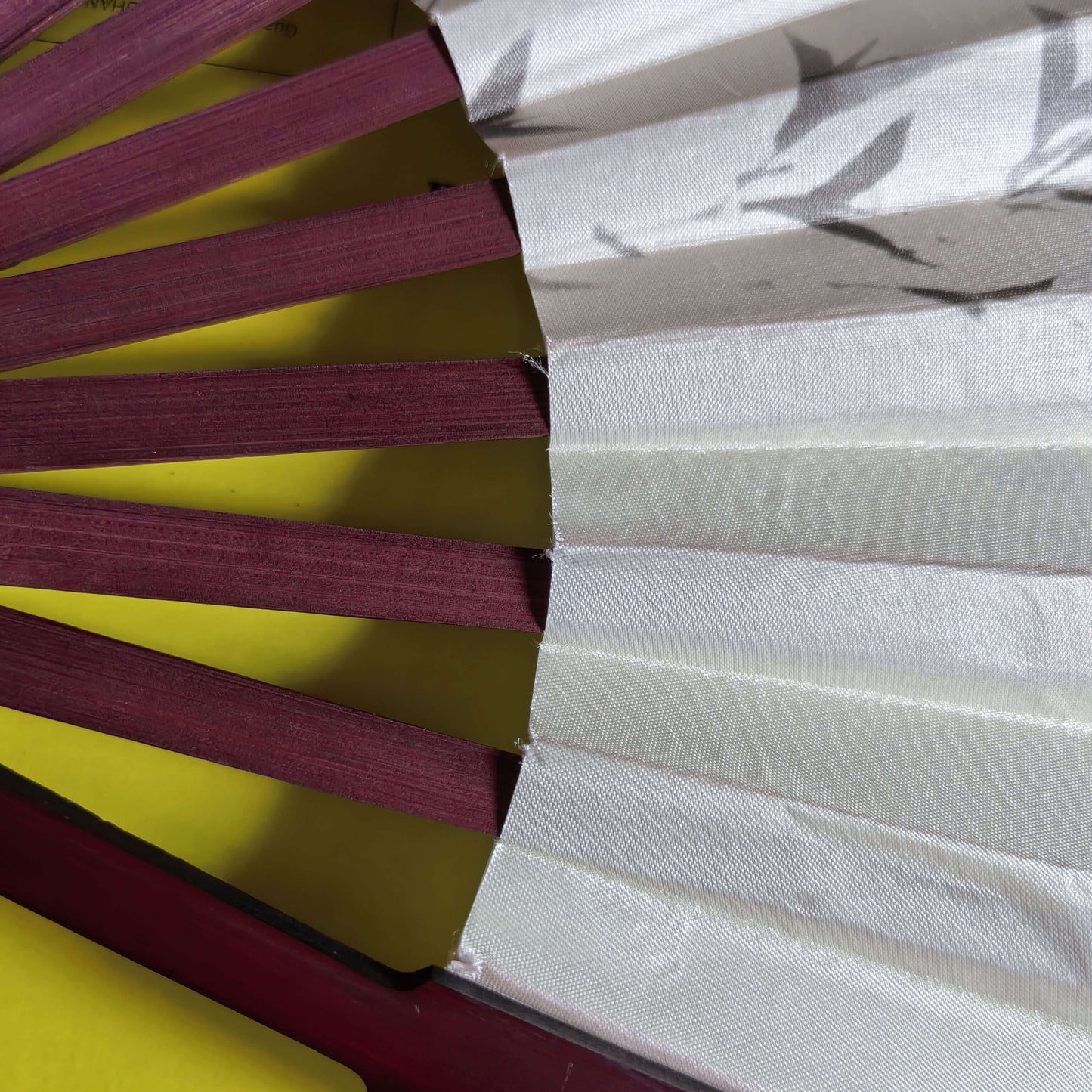 Close-up of a traditional Japanese fan with red wooden sticks and white paper