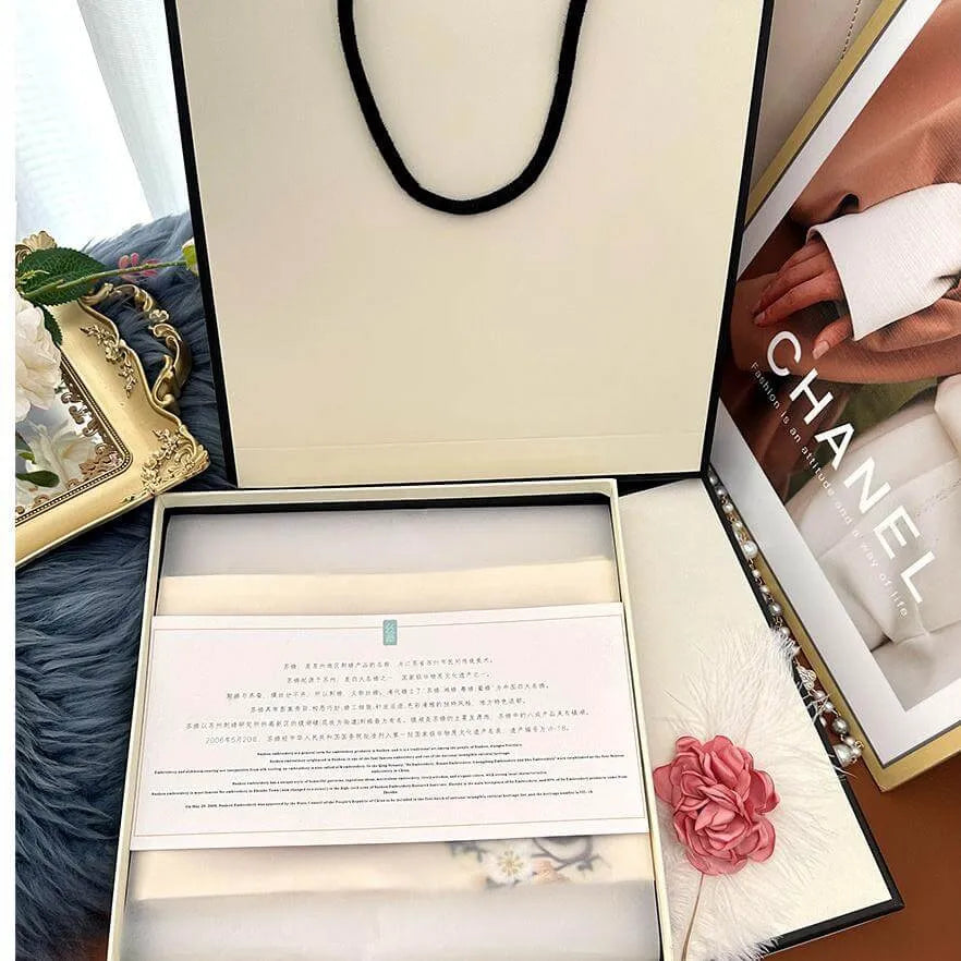 Chanel gift box with a pink flower accessory and brand name visible