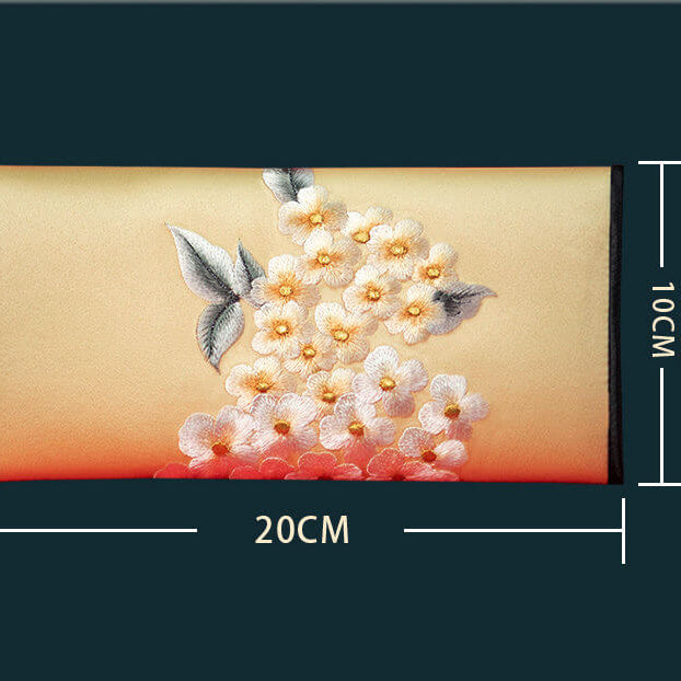 Embroidered pouch with floral design and measurements on a dark background