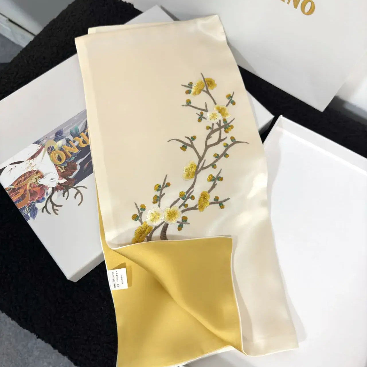 Embroidered fabric with floral design on a white background, featuring the brand 'Merri Darno'.