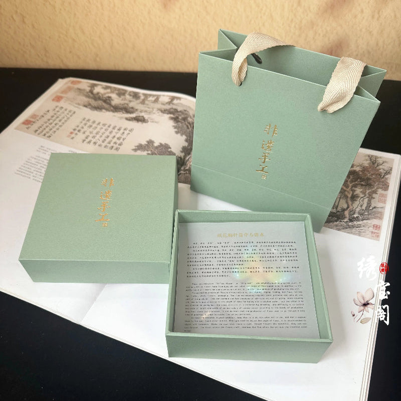 Green gift box with a message card on a textured surface