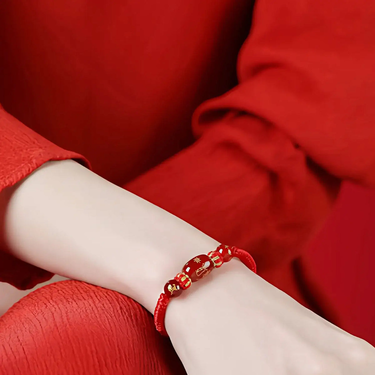 Red bracelet on a wrist with a red background