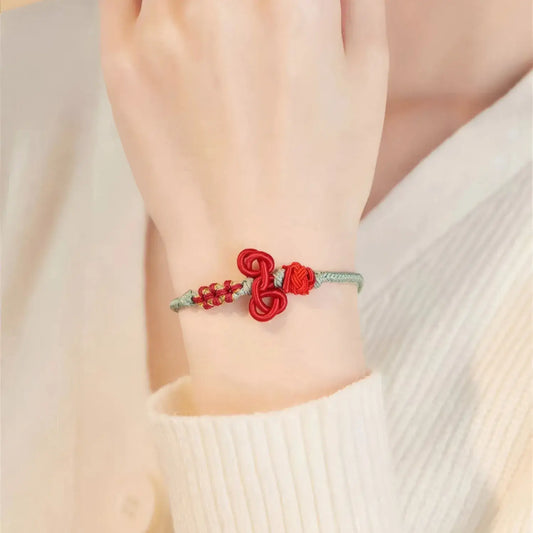 Red and silver bracelet on a wrist with a blurred background