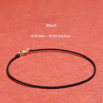 Black cord with a gold clasp on a red background