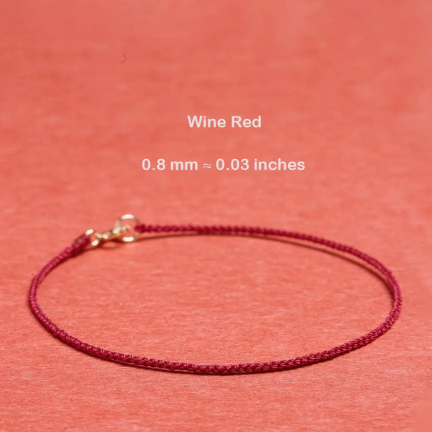 Wine red cord bracelet on a matching background with text indicating thickness.