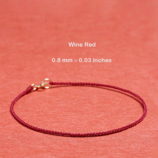 Wine red cord bracelet on a matching background with text indicating thickness.