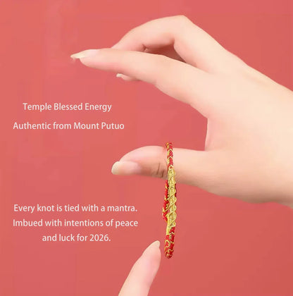 Hand holding a red and gold bracelet with text about Temple Blessed Energy and Mount Putuo.