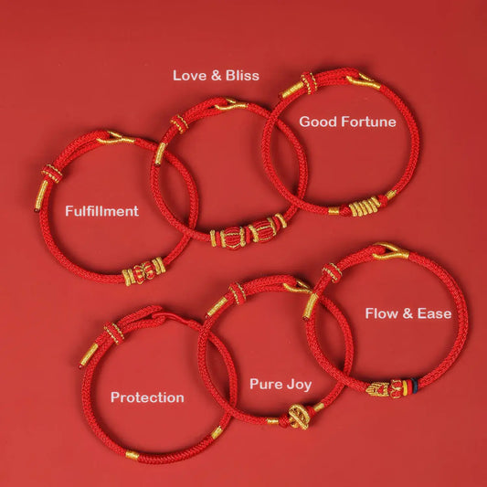 Set of red bracelets with gold accents on a red background, each labeled with a different blessing.