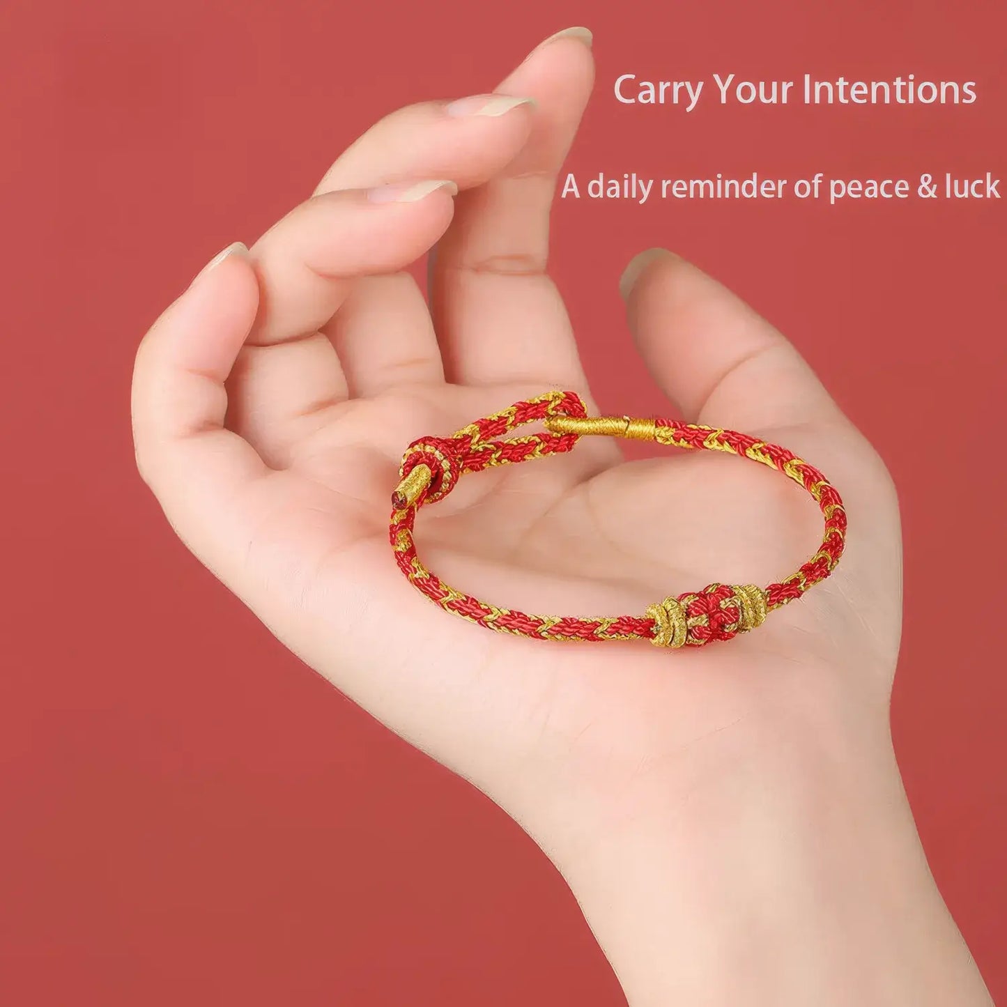 Hand holding a red and gold bracelet against a red background with text.