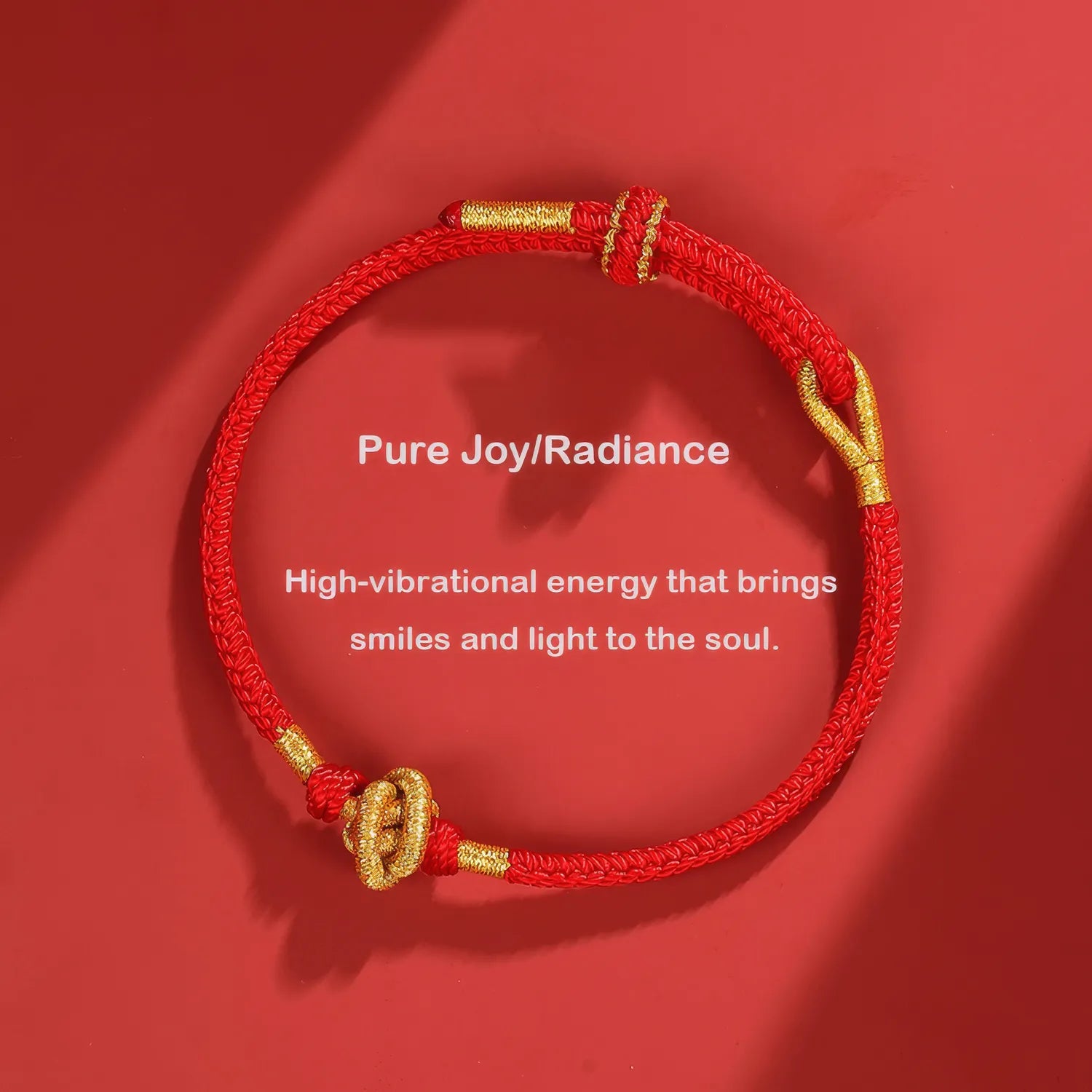 Red bracelet with gold accents on a red background, featuring text about high-vibrational energy.
