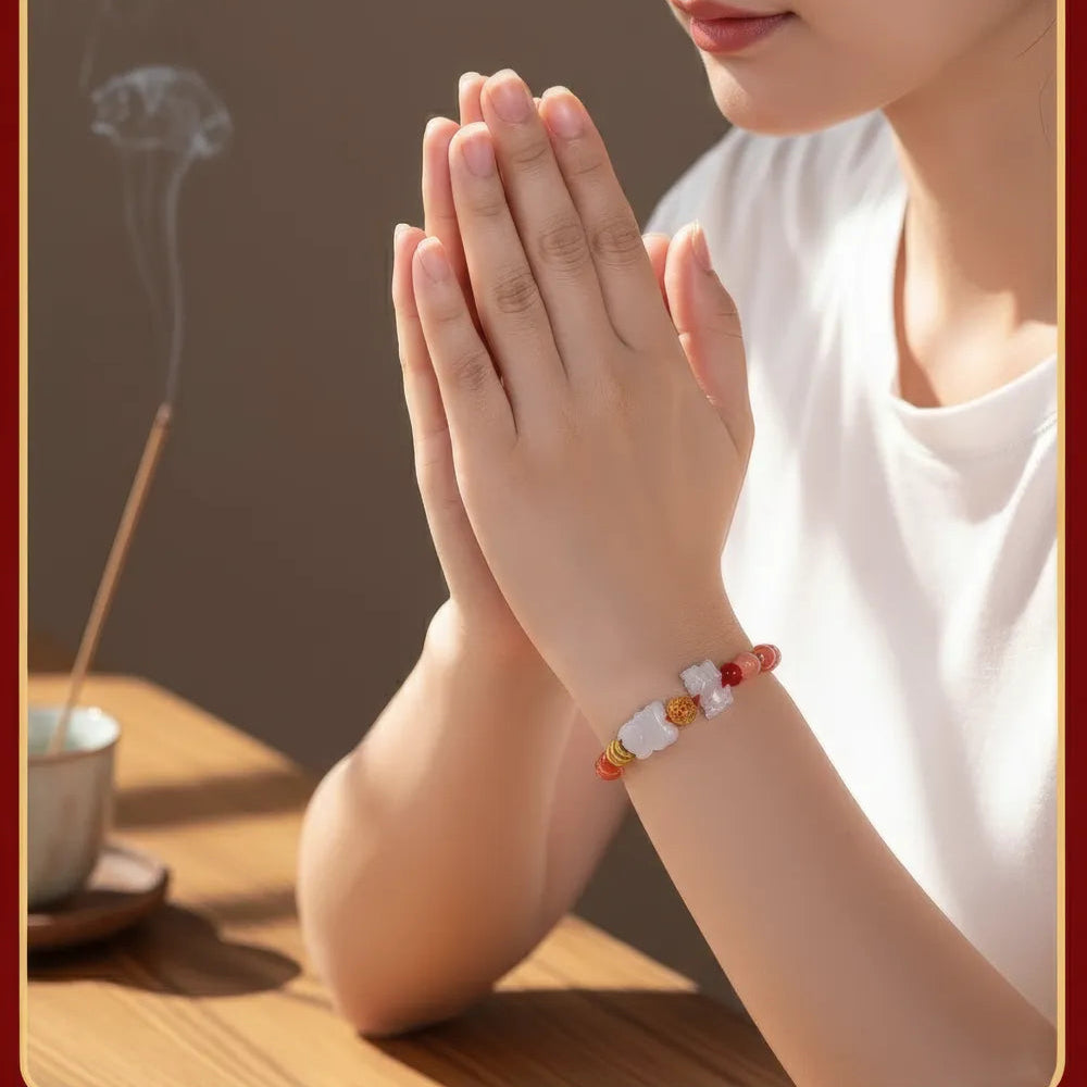 Woman with hands pressed together in prayer, wearing a bracelet, with incense and a cup on a wooden table.