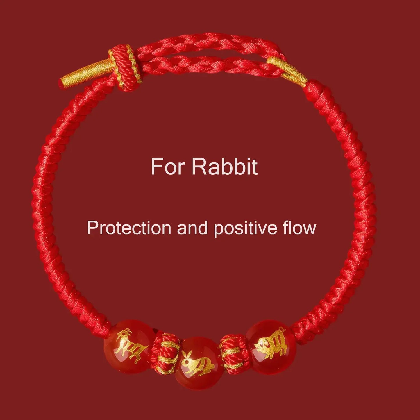 Red bracelet with gold accents and rabbit symbols on a red background