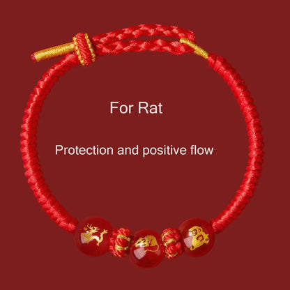 Red bracelet with gold accents and Chinese zodiac symbols on a red background