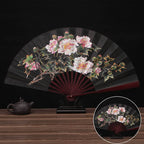 Decorative fan with floral design on a wooden table