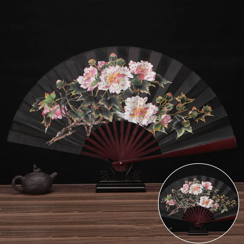Decorative fan with floral design on a wooden table