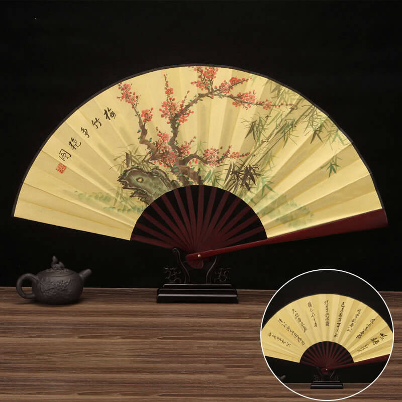 Traditional Chinese folding fan with floral design on a wooden surface