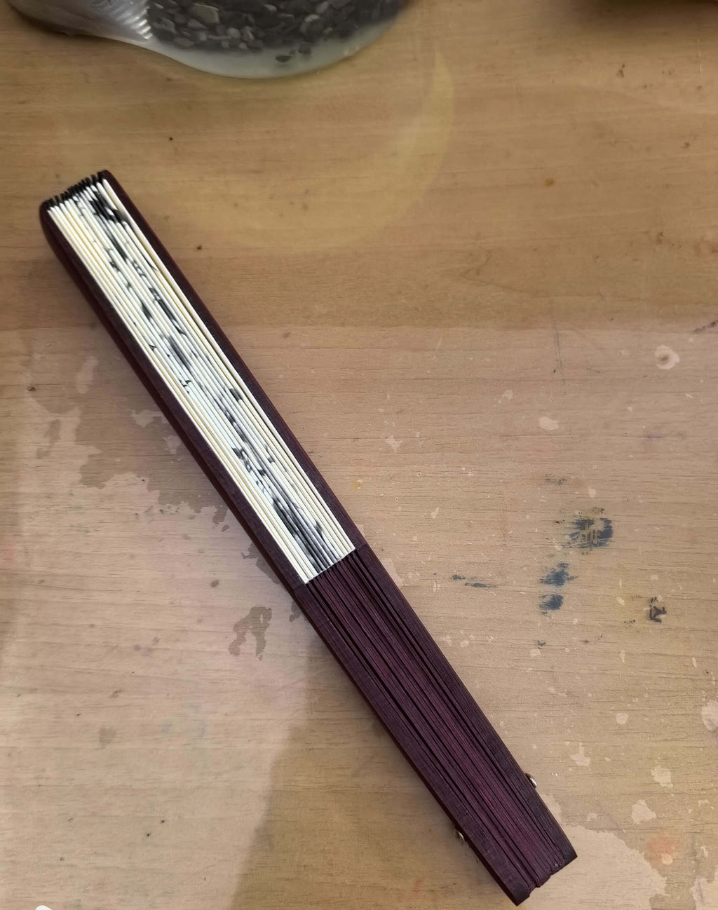 Folded fan with metallic accents on a wooden surface