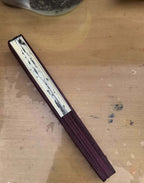 Folded fan with metallic accents on a wooden surface