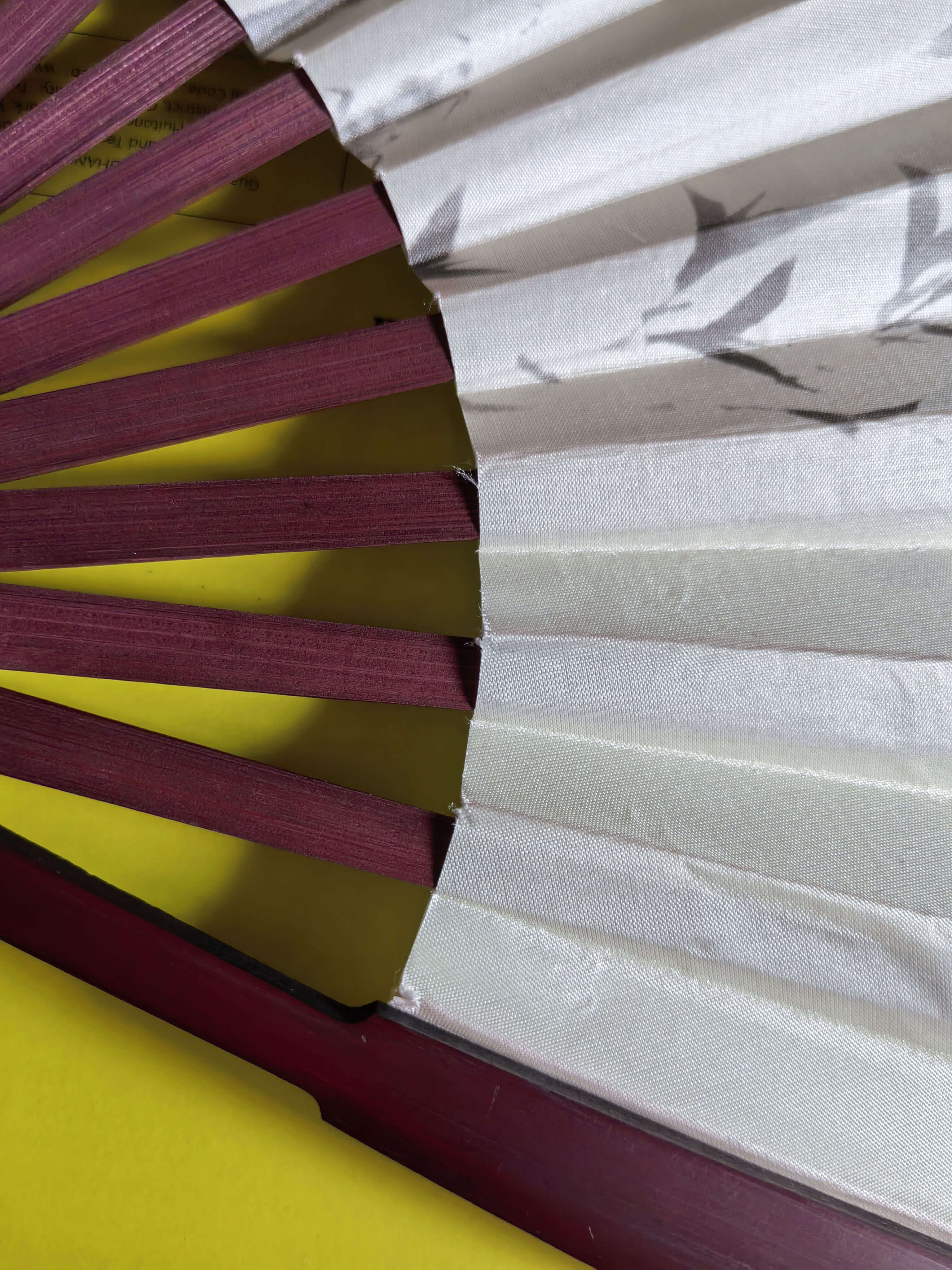 Close-up of a traditional Japanese fan with red wooden sticks and white paper
