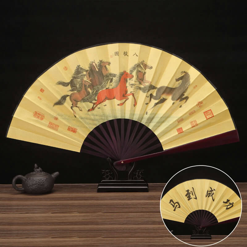 Decorative fan with horse design on a wooden surface
