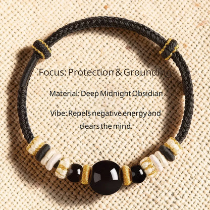 Black braided bracelet with beads on a textured beige background
