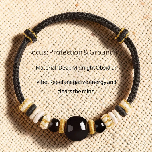 Black braided bracelet with beads on a textured beige background