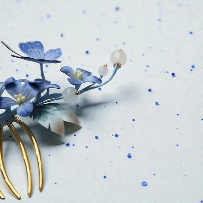 Decorative hairpin with blue floral design on a light background
