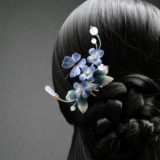 Hair accessory with blue flowers on a braided hairstyle against a gray background
