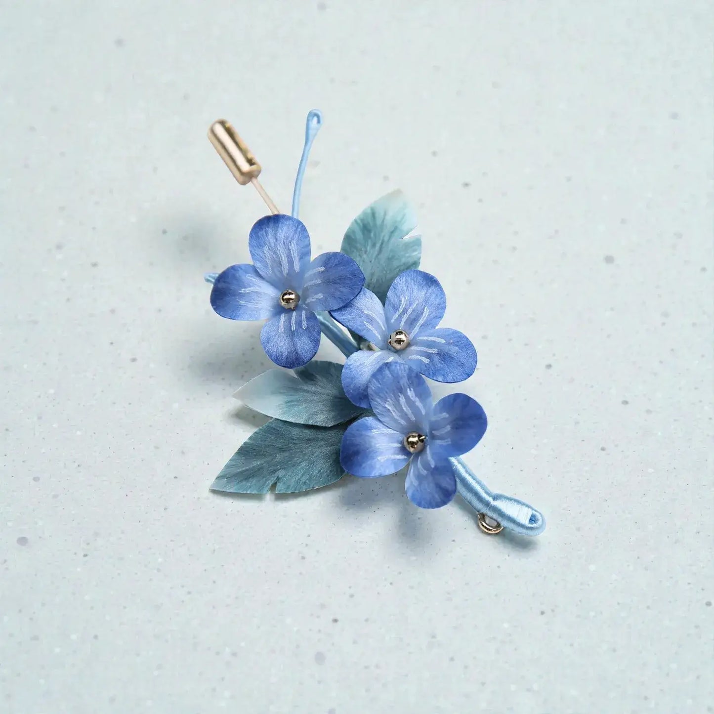 Blue floral hair clip on a light gray background