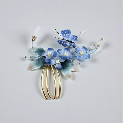 Decorative hair comb with blue flowers and a butterfly on a light gray background
