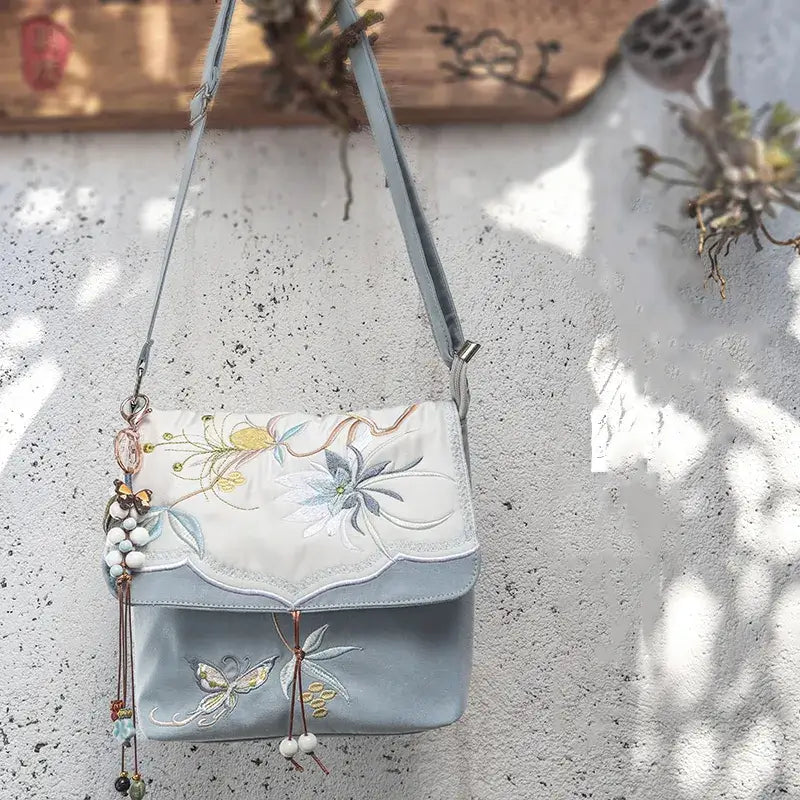 Embroidered handbag with floral designs on a textured surface