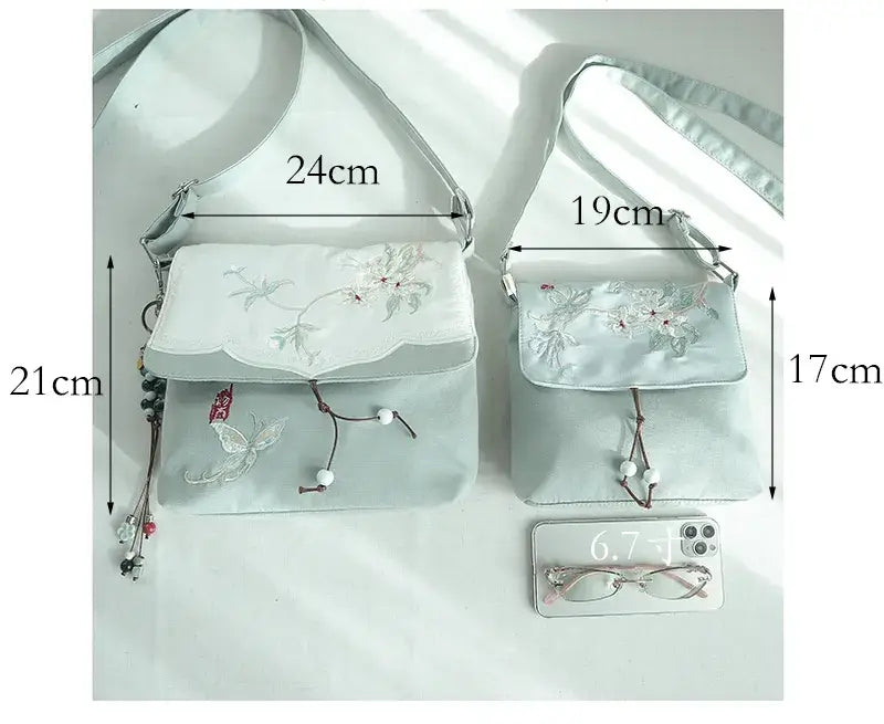 Two handbags with floral embroidery and measurements on a white background