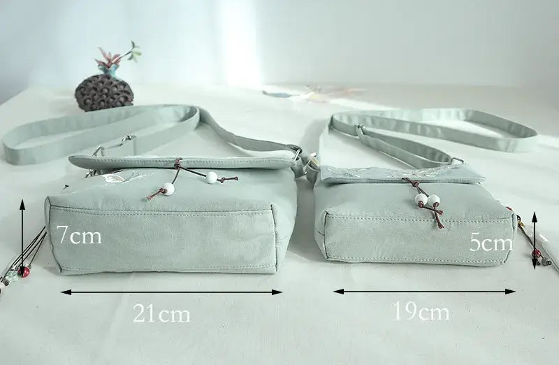 Light gray crossbody bag with measurements on a white background