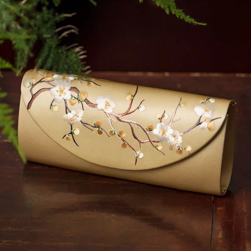 Beige clutch with floral design on a wooden surface