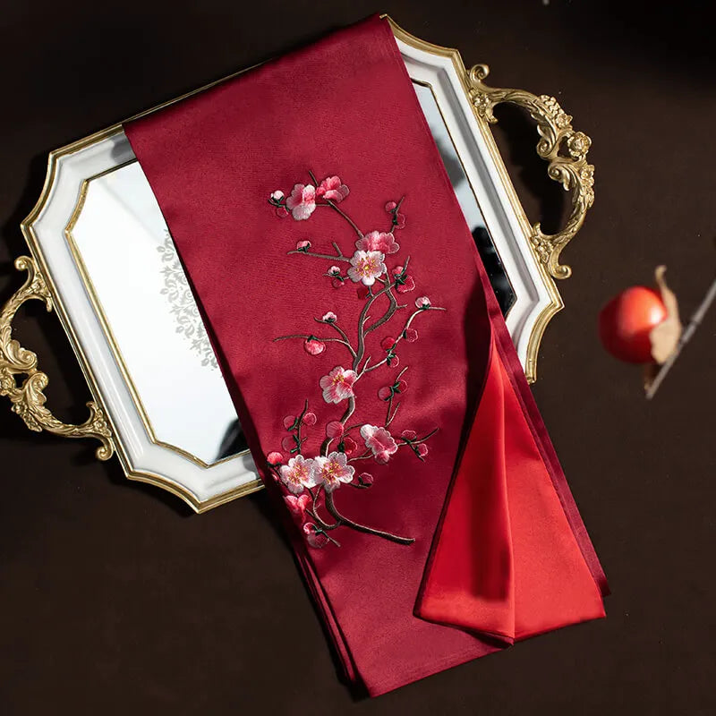 Red embroidered fabric with floral design on a decorative tray