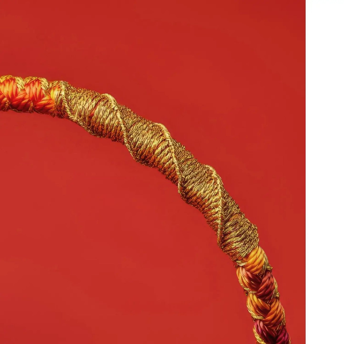 Coiled rope with orange and gold colors on a red background