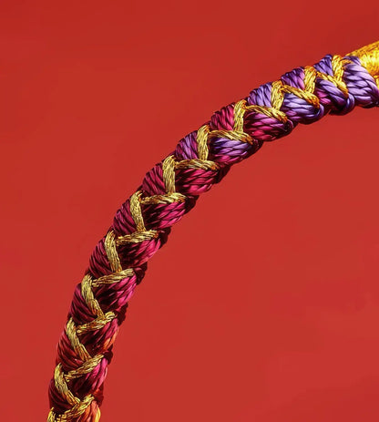 Braided cord with gold, purple, and red colors on a red background