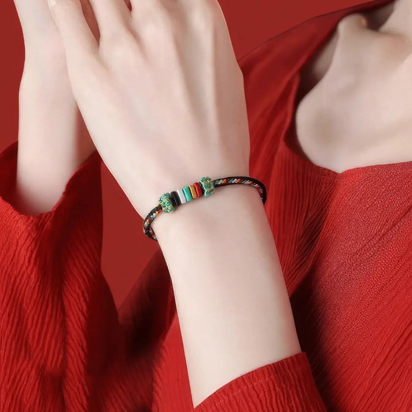 Colorful beaded bracelet on a wrist against a red background