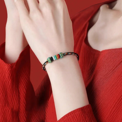 Colorful beaded bracelet on a wrist against a red background