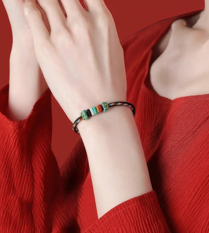 Colorful beaded bracelet on a wrist against a red background