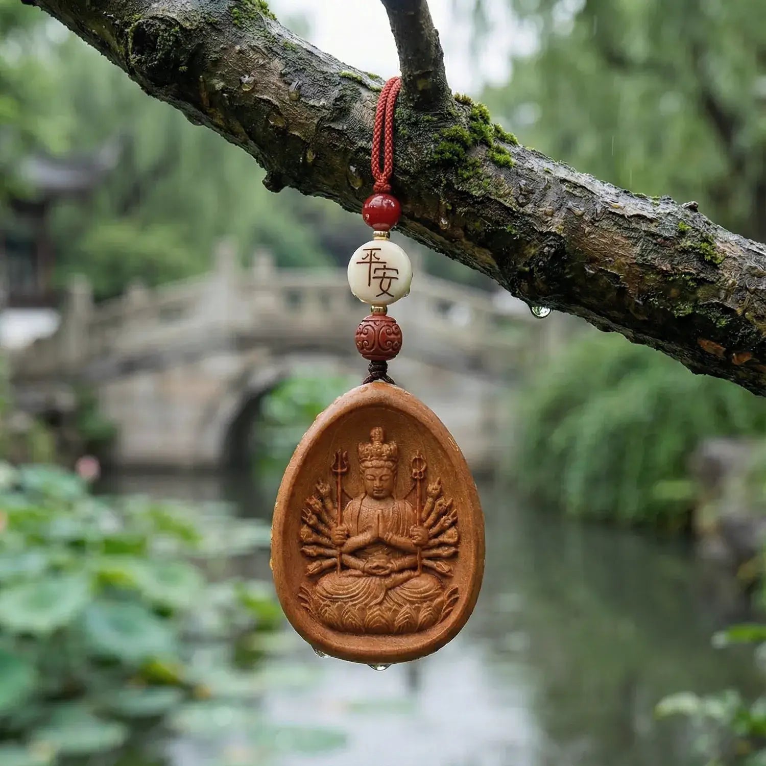 Pendant with a religious figure on a tree branch with a blurred natural background