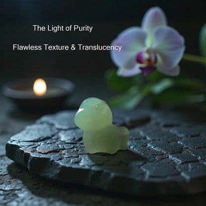 Translucent green stone sculpture on a dark surface with a candle and orchid in the background.