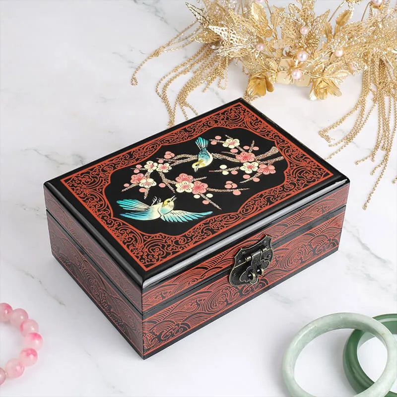Decorative wooden box with floral and bird design on a white surface