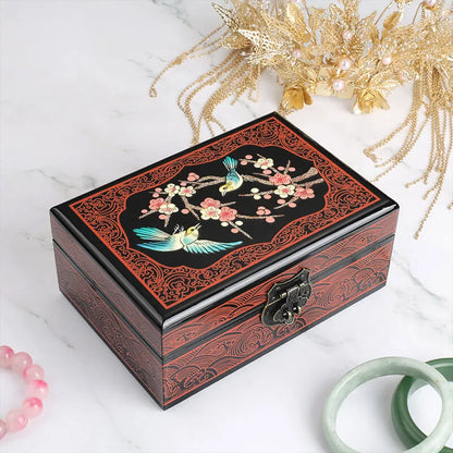 Decorative wooden box with floral and bird design on a white surface