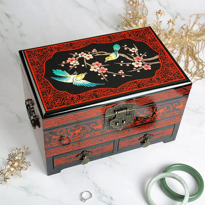 Decorative jewelry box with bird and floral patterns on a marble surface