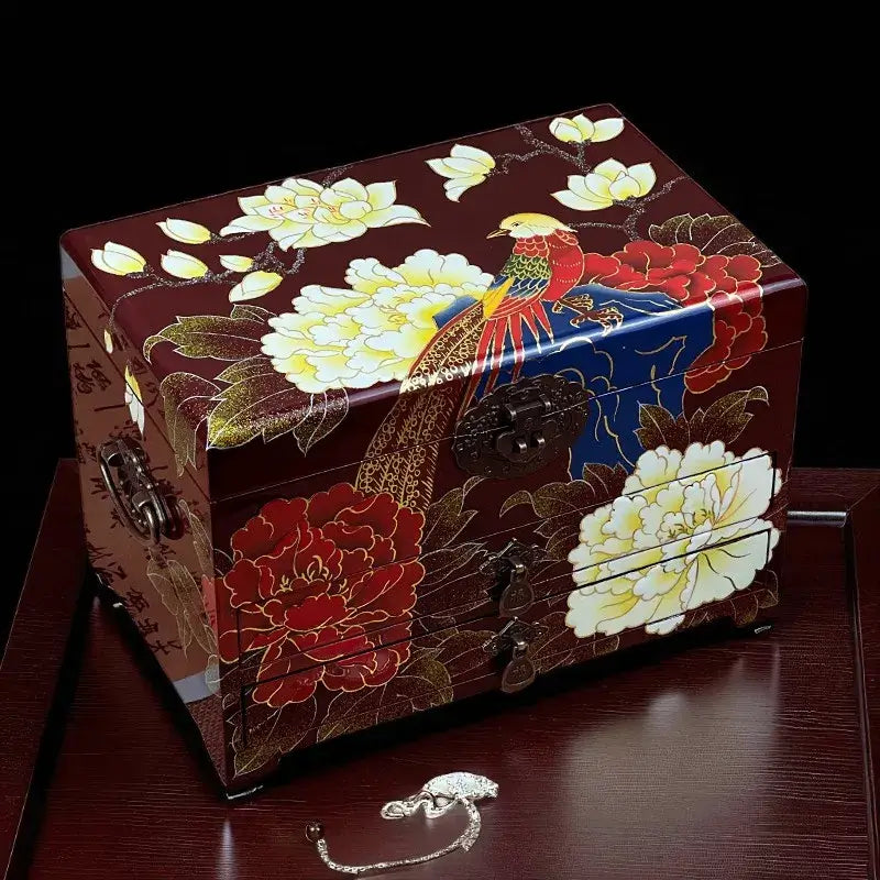 Decorative jewelry box with floral and bird design on a dark background