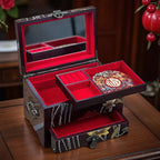 Jewelry box with red interior and floral designs on a wooden surface