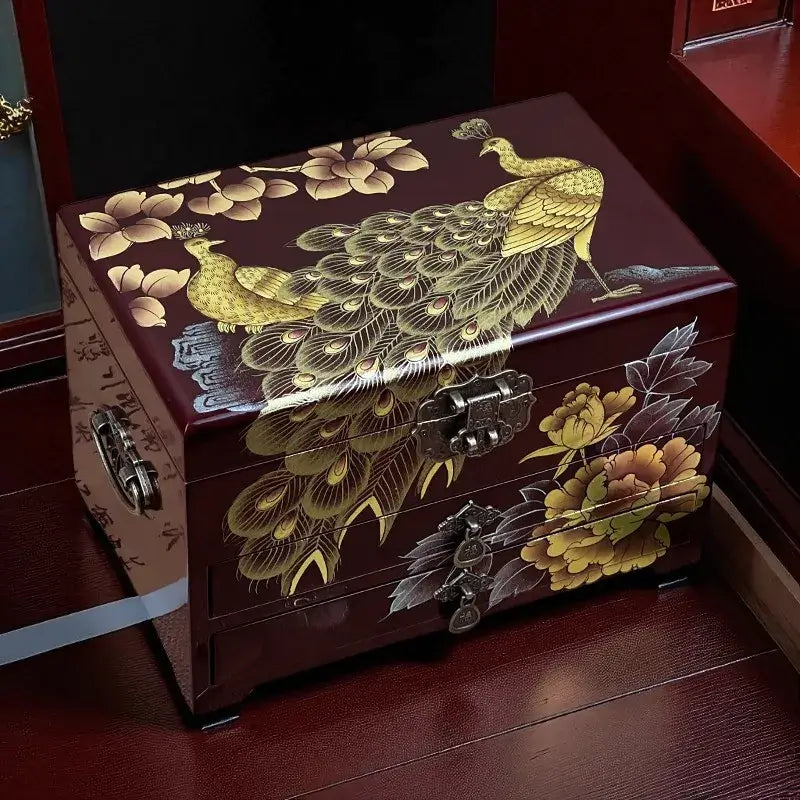 Decorative wooden box with peacock and floral designs on a wooden floor.