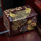 Decorative wooden box with peacock and floral designs on a wooden floor.