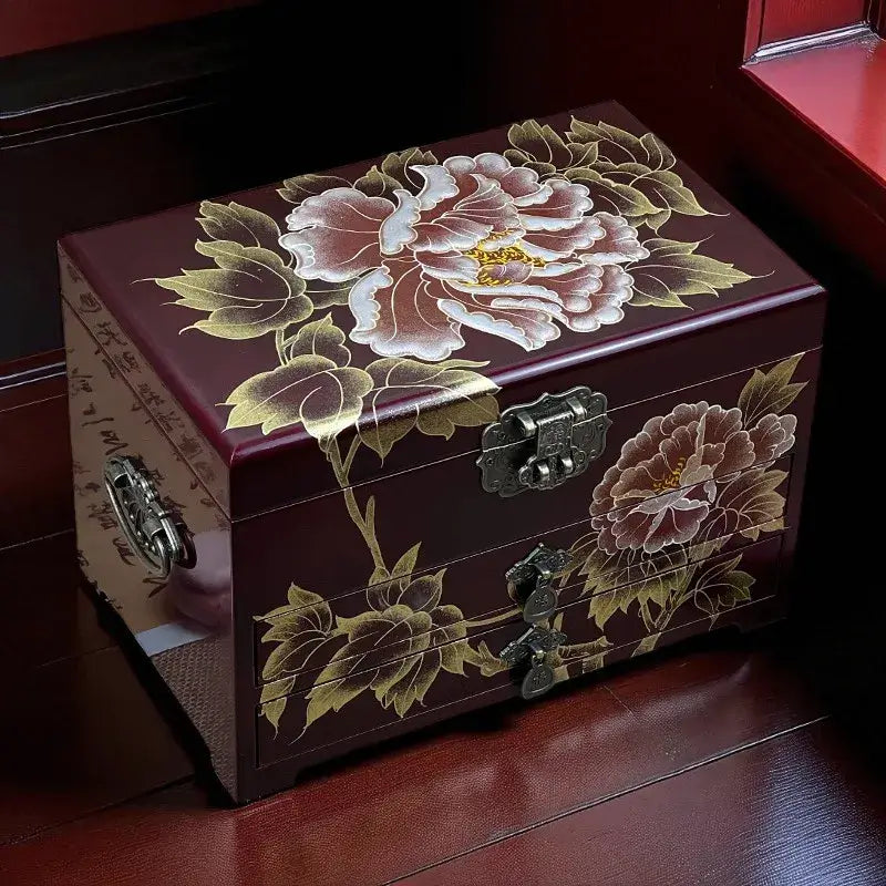 Decorative wooden box with floral designs on a dark surface
